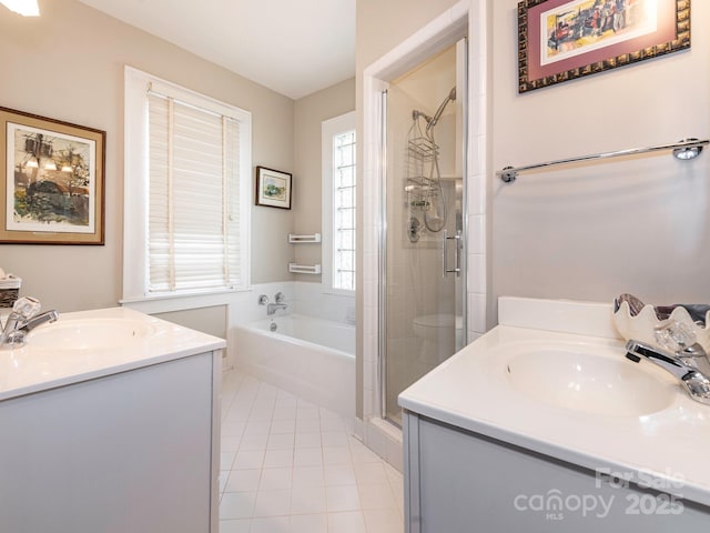 bathroom with a stall shower, two vanities, a sink, and tile patterned floors