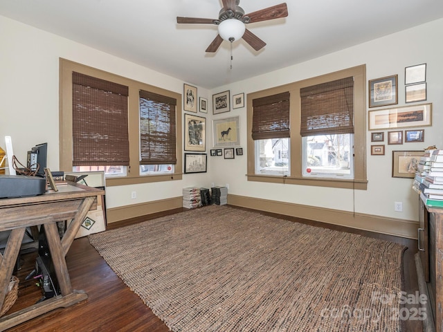 office featuring a ceiling fan, baseboards, and wood finished floors