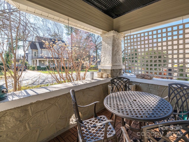 balcony with outdoor dining area and a residential view