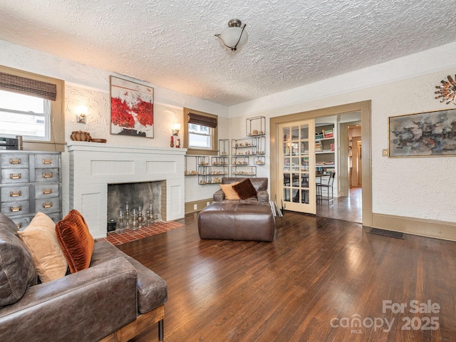 living area with plenty of natural light, wood finished floors, and a textured wall