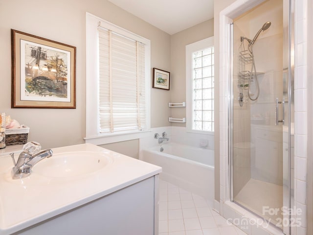 bathroom featuring a stall shower, a garden tub, vanity, and tile patterned floors