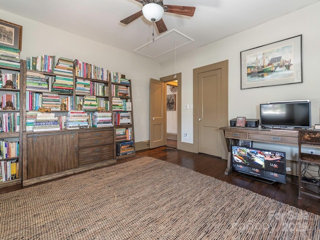 interior space with attic access, baseboards, ceiling fan, and wood finished floors