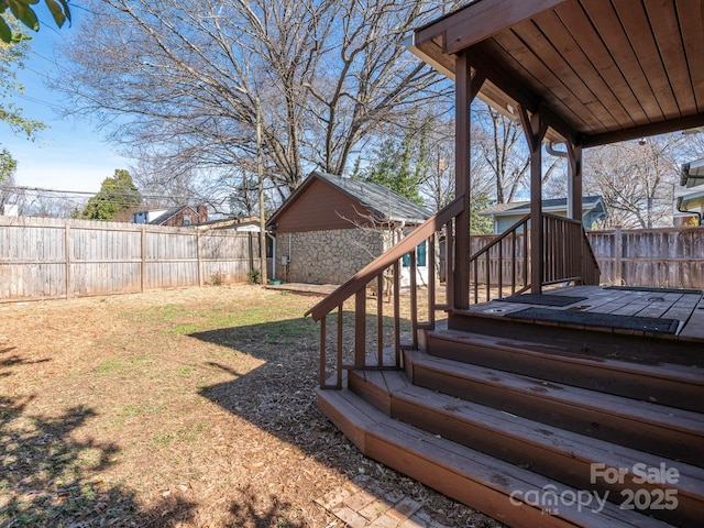 exterior space with a deck, an outdoor structure, and a fenced backyard