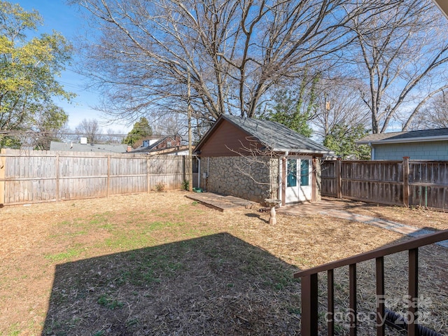 view of yard with a fenced backyard and an outbuilding