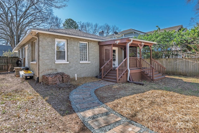 view of front of home featuring roof with shingles, fence, and a chimney