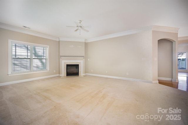 unfurnished living room with crown molding, a fireplace with flush hearth, visible vents, and light colored carpet