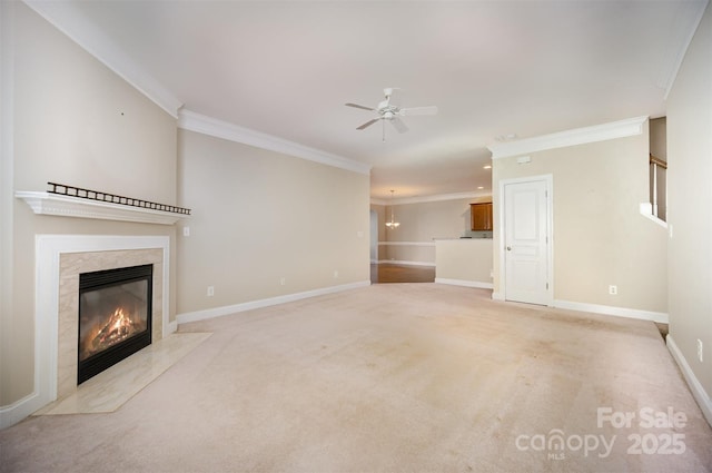 unfurnished living room featuring ceiling fan, light carpet, a high end fireplace, baseboards, and ornamental molding