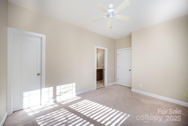 unfurnished bedroom with baseboards, connected bathroom, and light colored carpet