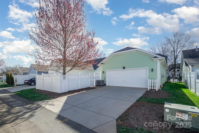 view of property exterior featuring a garage, driveway, a fenced front yard, and cooling unit