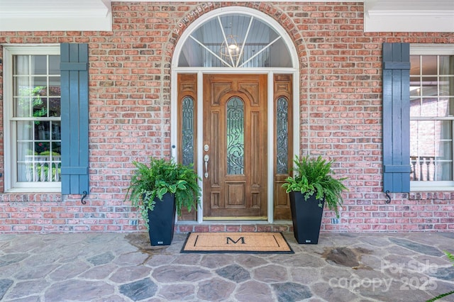 doorway to property with brick siding