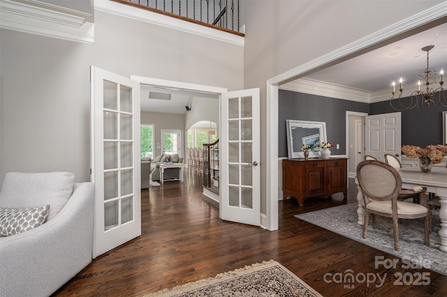 dining room with french doors, wood finished floors, a notable chandelier, and crown molding