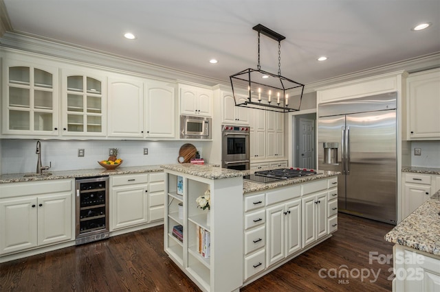 kitchen with wine cooler, a sink, a center island, tasteful backsplash, and built in appliances