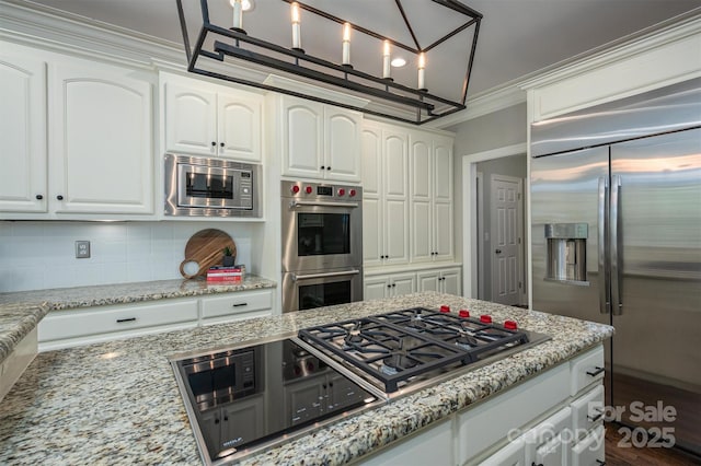 kitchen with white cabinetry, backsplash, built in appliances, light stone counters, and ornamental molding