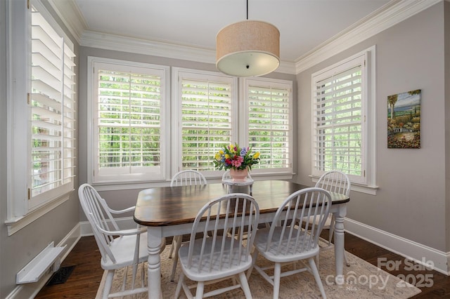 dining room with wood finished floors, a wealth of natural light, and ornamental molding