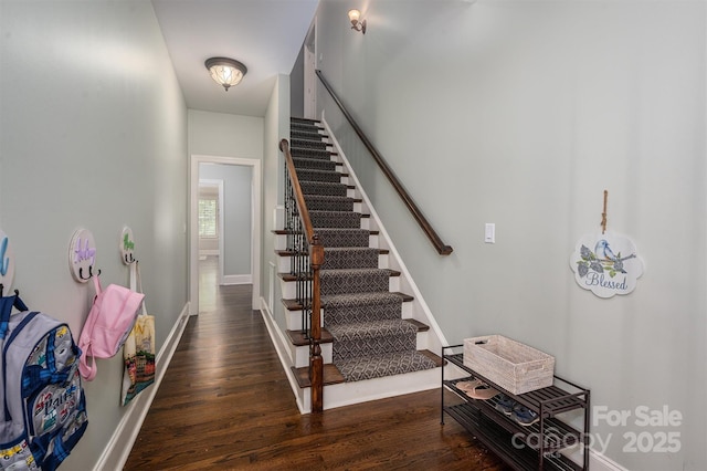 stairs with wood finished floors and baseboards