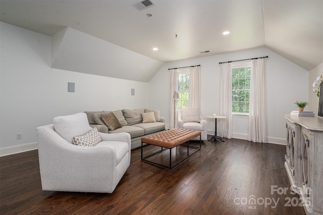 living room featuring dark wood finished floors, lofted ceiling, visible vents, and baseboards