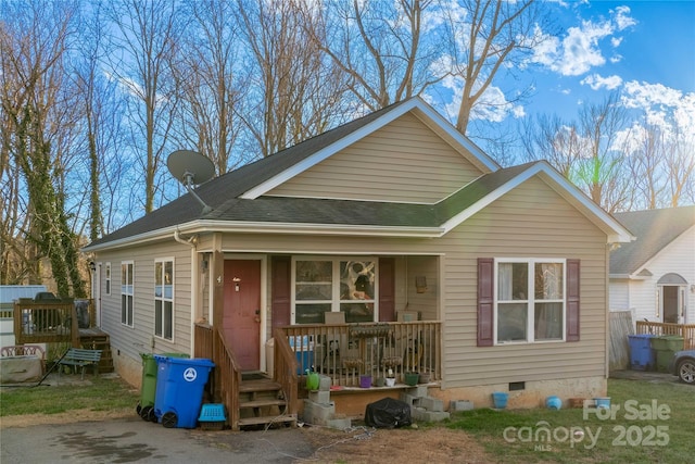 bungalow-style house featuring covered porch, roof with shingles, and crawl space