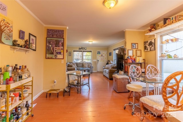 interior space with crown molding, baseboards, and wood finished floors