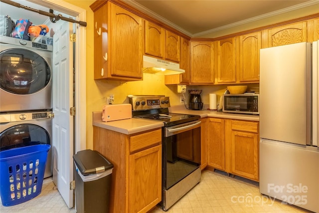 kitchen with under cabinet range hood, stainless steel appliances, stacked washer / drying machine, light countertops, and light floors