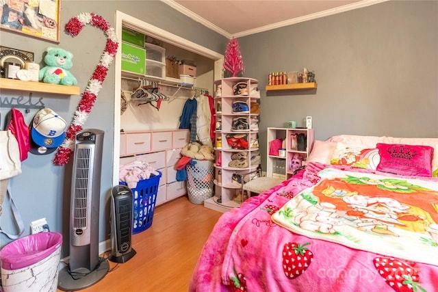 bedroom with a closet, wood finished floors, and crown molding