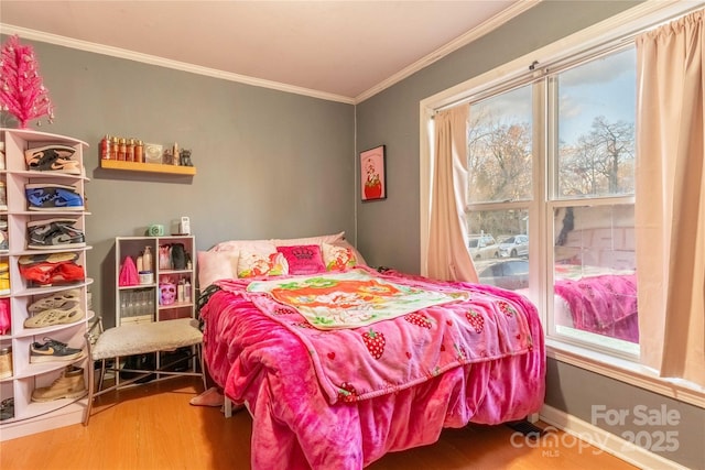 bedroom with baseboards, wood finished floors, and crown molding