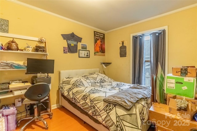 bedroom featuring baseboards, ornamental molding, and wood finished floors