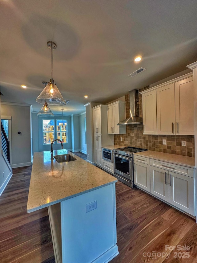 kitchen with a sink, visible vents, white cabinetry, wall chimney range hood, and stainless steel range with electric stovetop