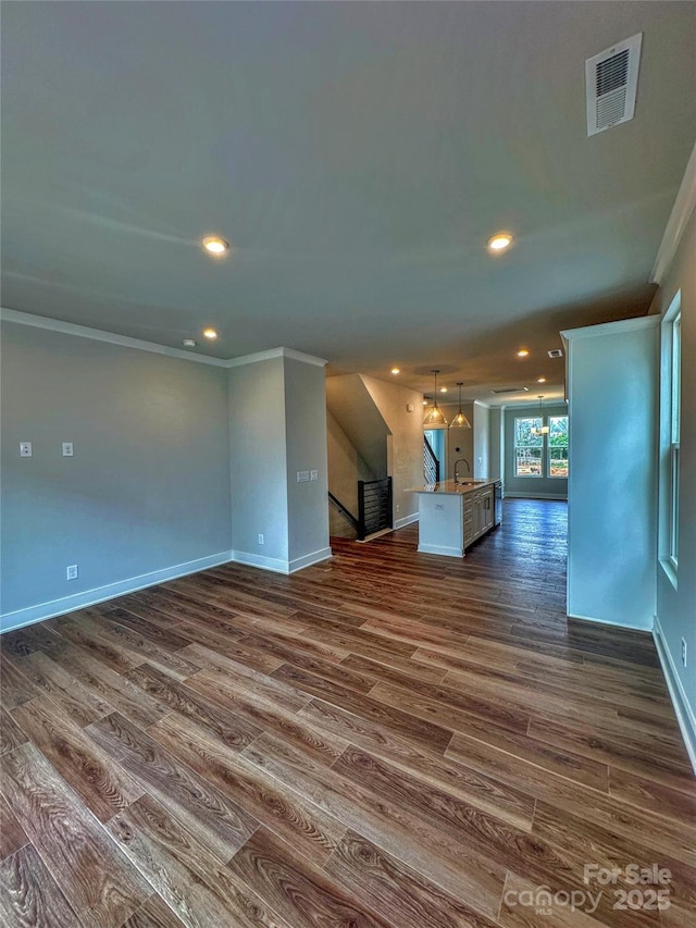 unfurnished living room featuring crown molding, recessed lighting, visible vents, dark wood-type flooring, and baseboards