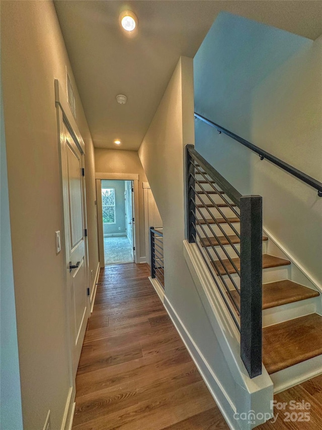 interior space with stairway, wood finished floors, and baseboards