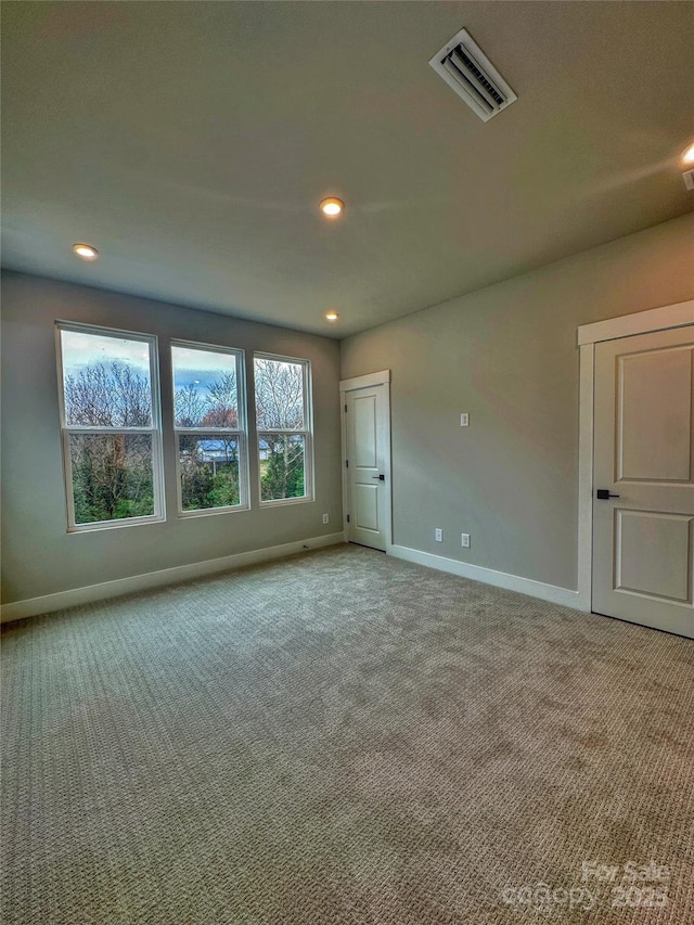 unfurnished room featuring carpet floors, baseboards, visible vents, and recessed lighting