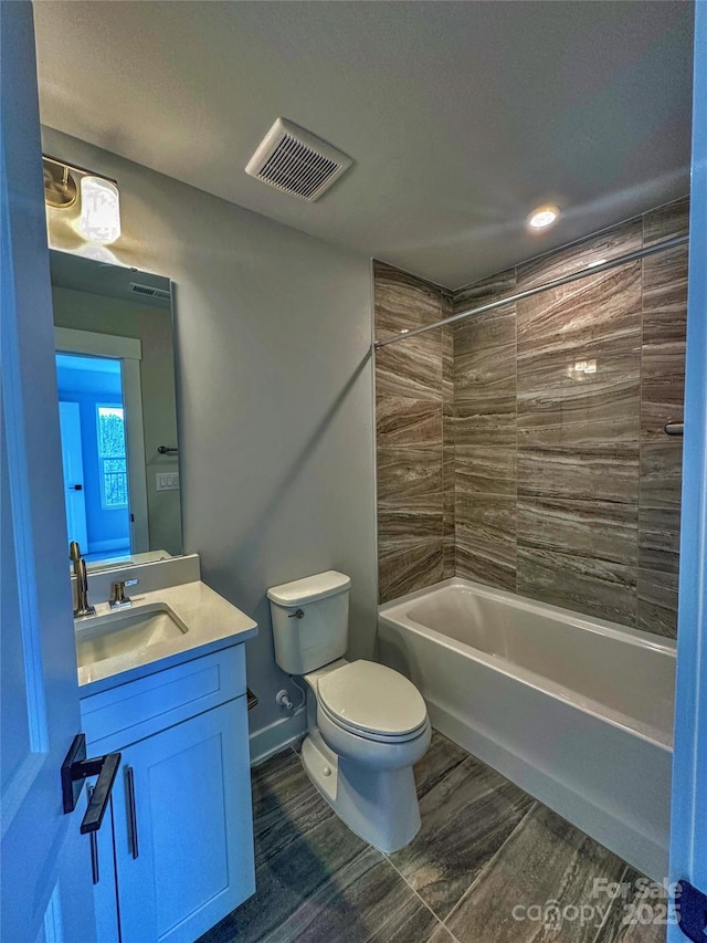 bathroom with shower / bath combination, visible vents, toilet, vanity, and wood finished floors