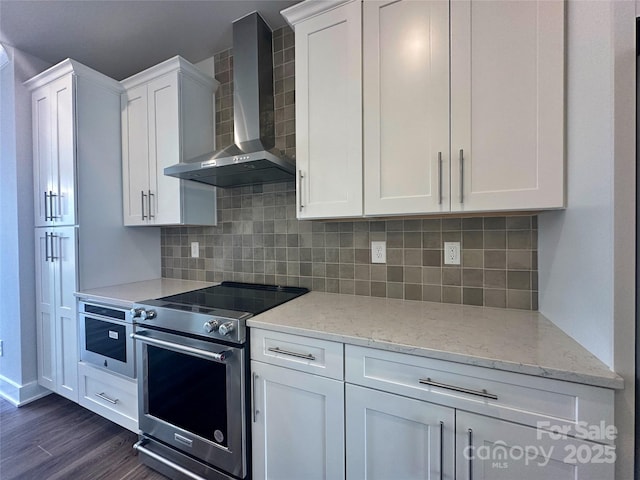 kitchen featuring white cabinetry, wall chimney range hood, and stainless steel appliances