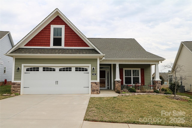 craftsman-style home featuring stone siding, roof with shingles, covered porch, and a front yard