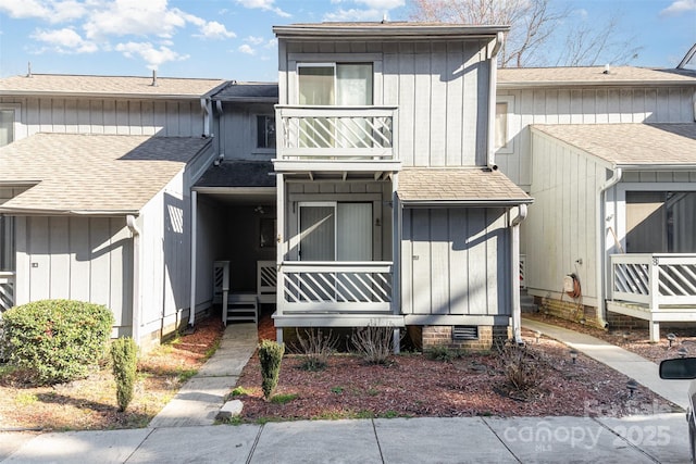 townhome / multi-family property featuring a shingled roof, a porch, board and batten siding, crawl space, and a balcony