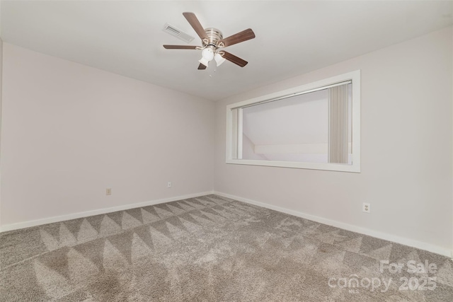 carpeted empty room featuring ceiling fan and baseboards