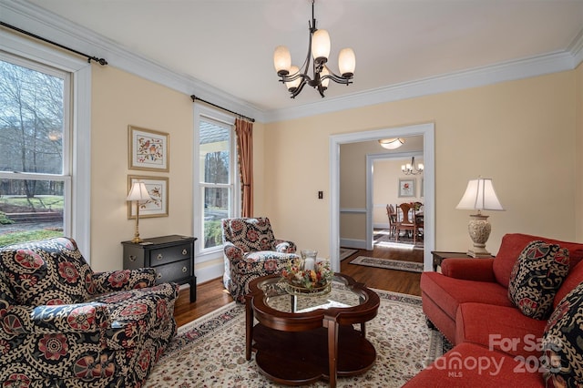 living room featuring crown molding, wood finished floors, and a notable chandelier