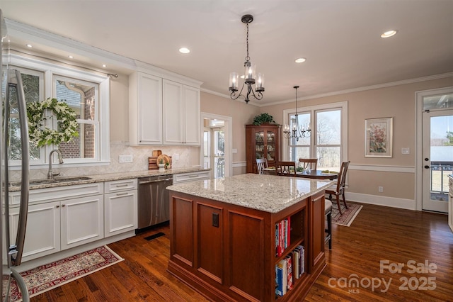 kitchen with dark wood-style flooring, crown molding, stainless steel dishwasher, a sink, and a chandelier