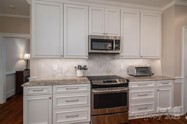 kitchen featuring white cabinets, a toaster, appliances with stainless steel finishes, and tasteful backsplash