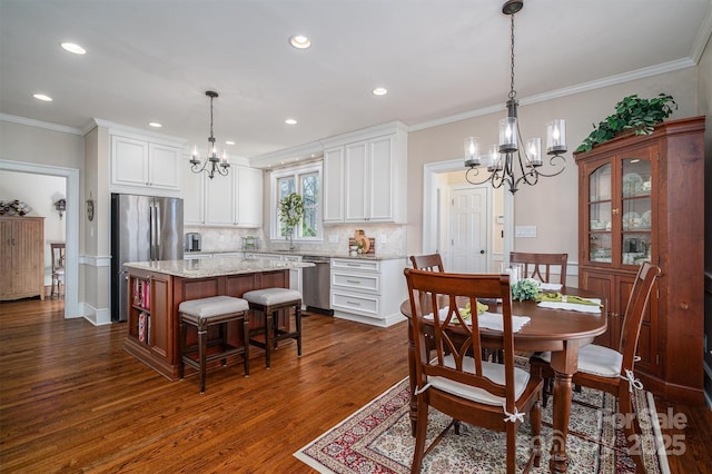 dining space featuring a chandelier, dark wood-type flooring, ornamental molding, and recessed lighting