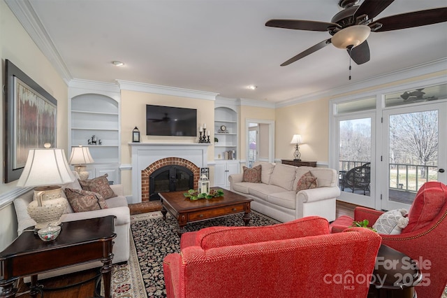 living room featuring crown molding, a brick fireplace, and built in features