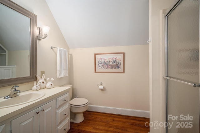 full bath with baseboards, lofted ceiling, wood finished floors, a shower with shower door, and vanity