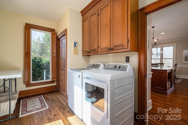 laundry room featuring cabinet space, washing machine and dryer, baseboards, and dark wood-type flooring