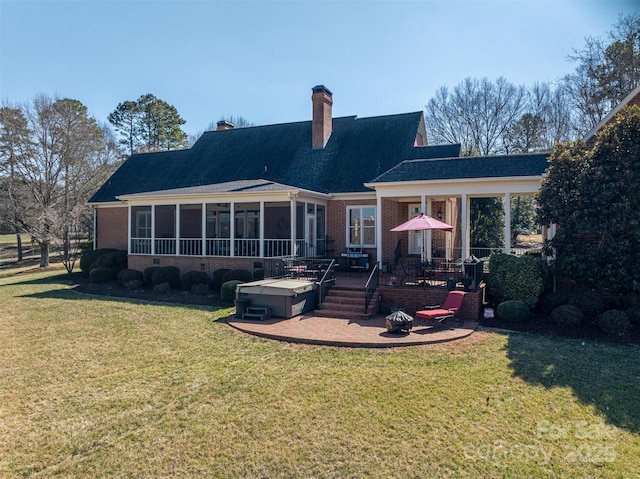 rear view of house with an outdoor fire pit, a lawn, a sunroom, a chimney, and brick siding