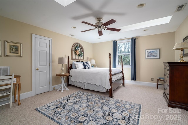 bedroom featuring a skylight, baseboards, visible vents, and light colored carpet