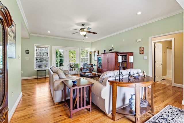 living room with light wood-style flooring, a ceiling fan, recessed lighting, crown molding, and baseboards