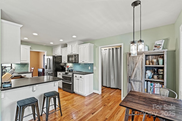 kitchen with dark countertops, white cabinets, and stainless steel appliances