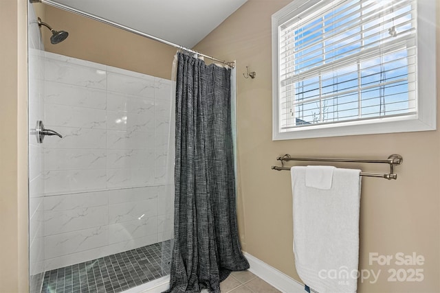 bathroom with tile patterned floors, baseboards, and a shower stall