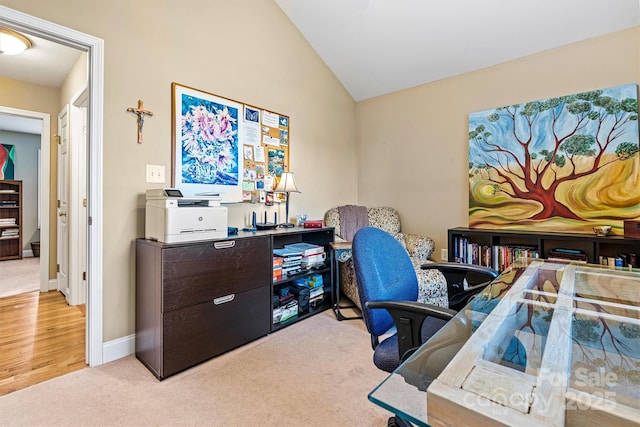 home office with light carpet, baseboards, and lofted ceiling