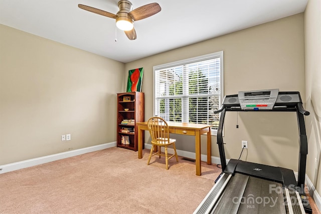 exercise area with light colored carpet, baseboards, and ceiling fan