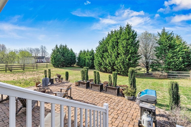 view of yard featuring a rural view, fence, and a patio area